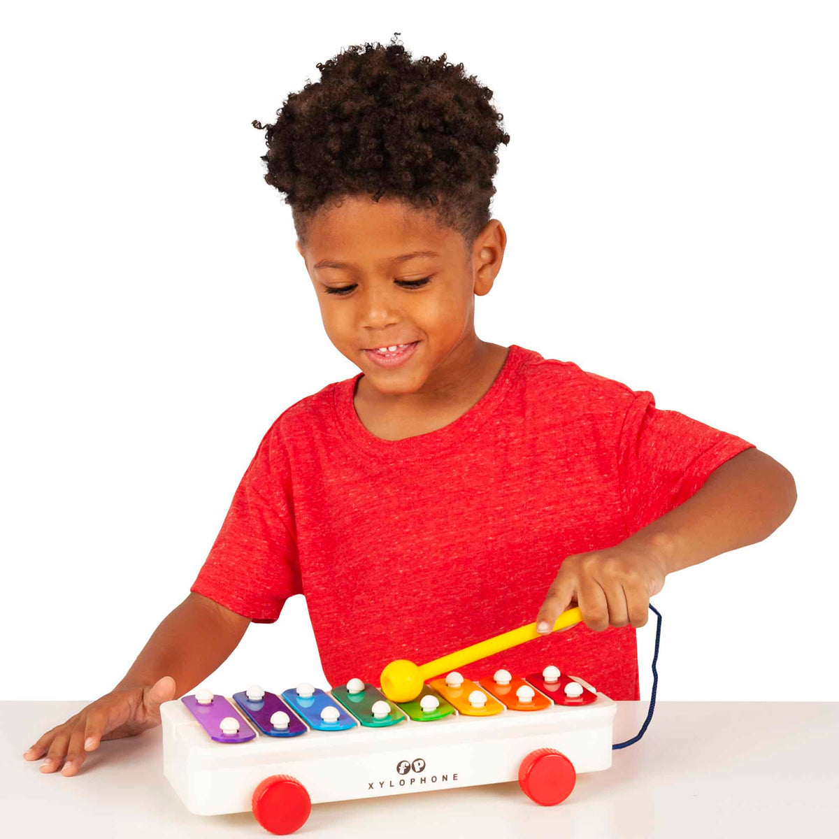 Lifestyle shot of boy playing with the Pull-A-Tune Xylophone