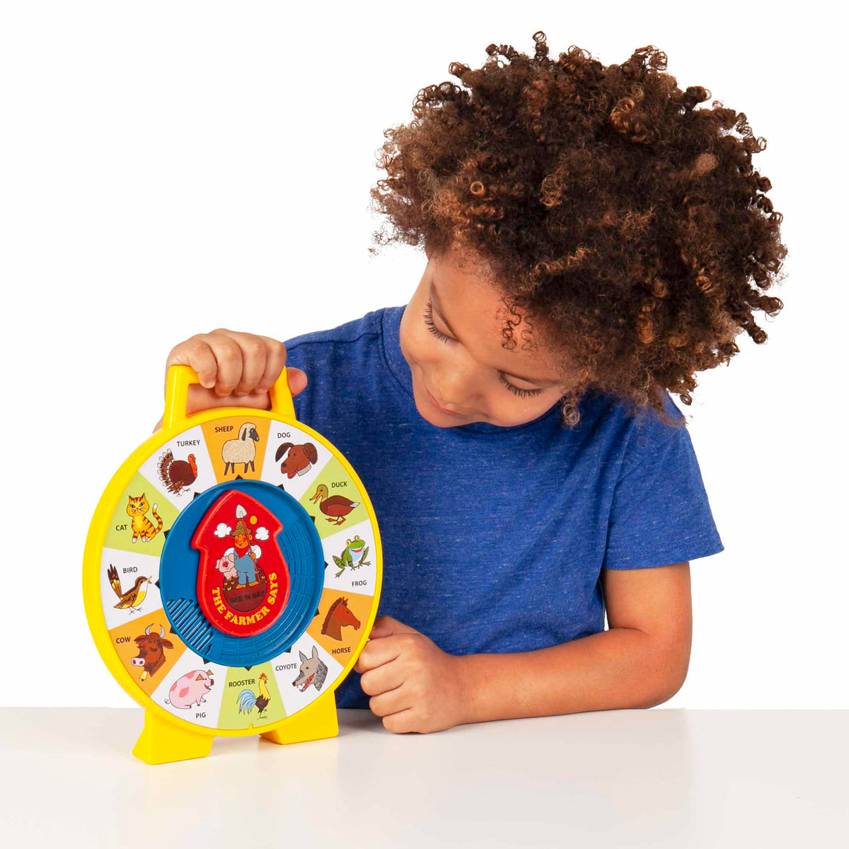 Lifestyle shot of boy looking at the See N Say on a table top