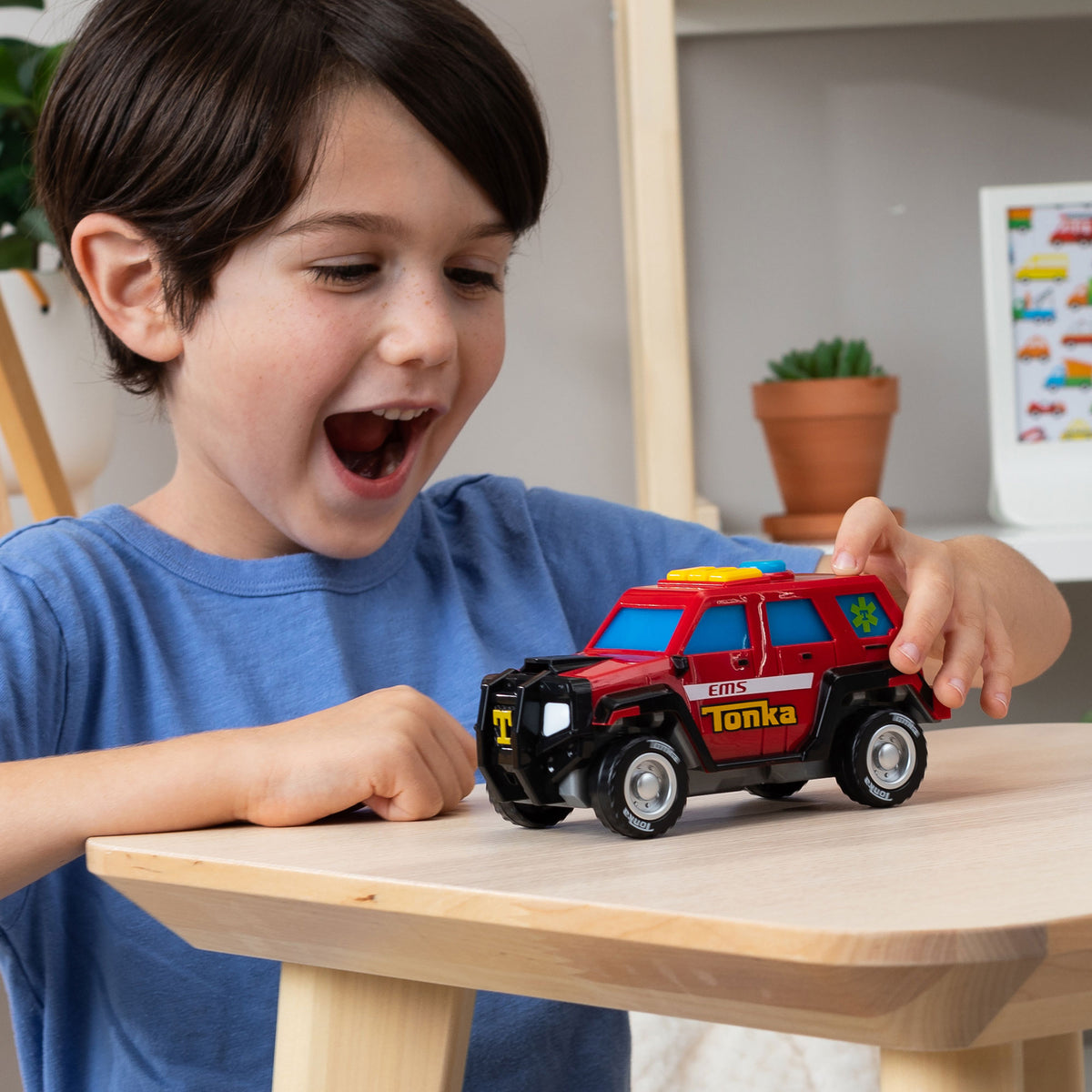 Mighty Force - First Responder - Lifestyle shot of excited boy paying with vehicle on a table